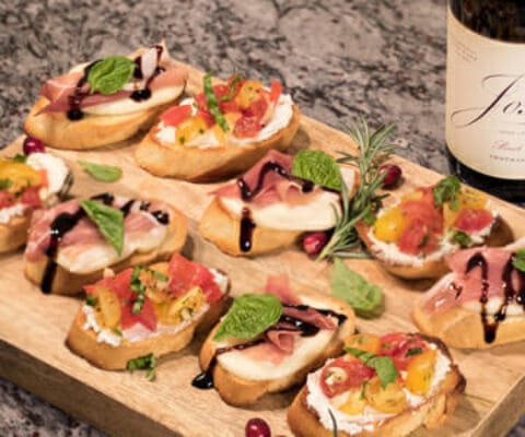 Picture of Bruschetta next to a bottle of Josh wines